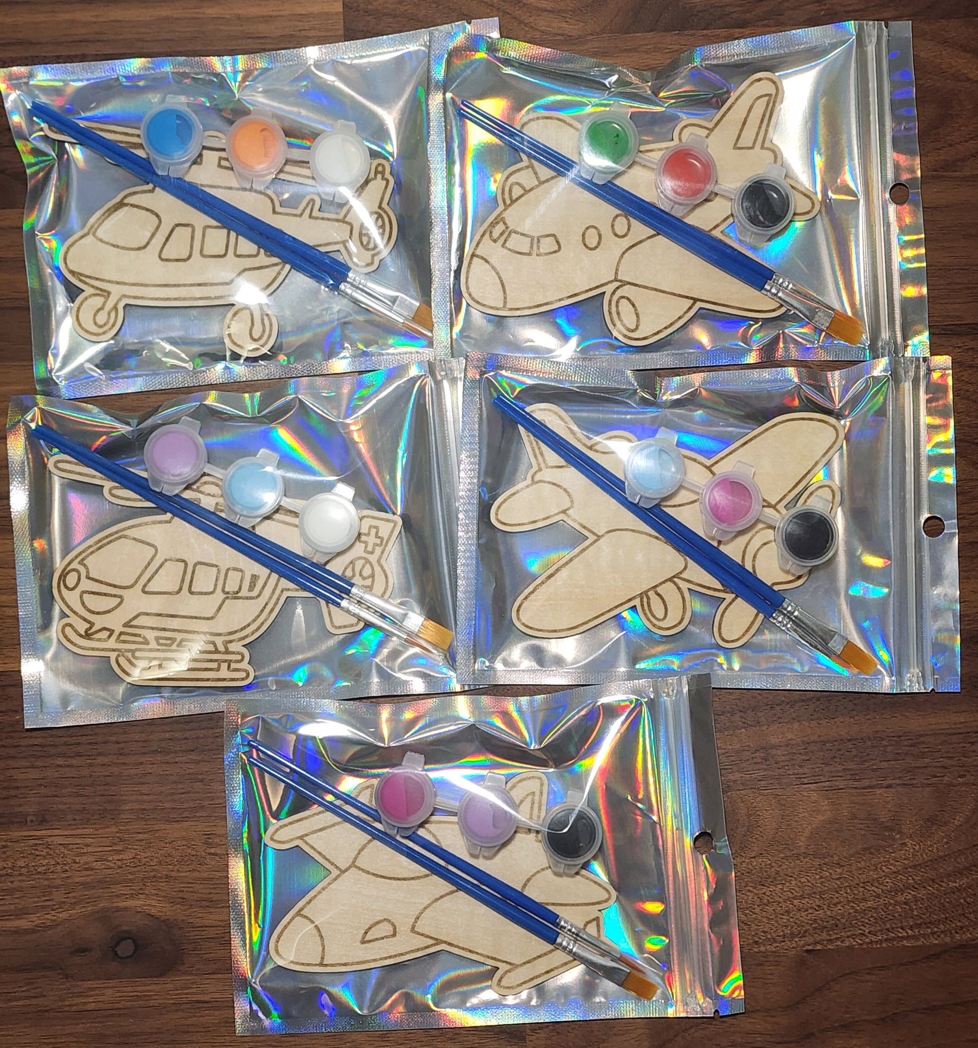 Airplane and Helicopter themed wooden engraved paint kits in a holographic bag with paint brushes