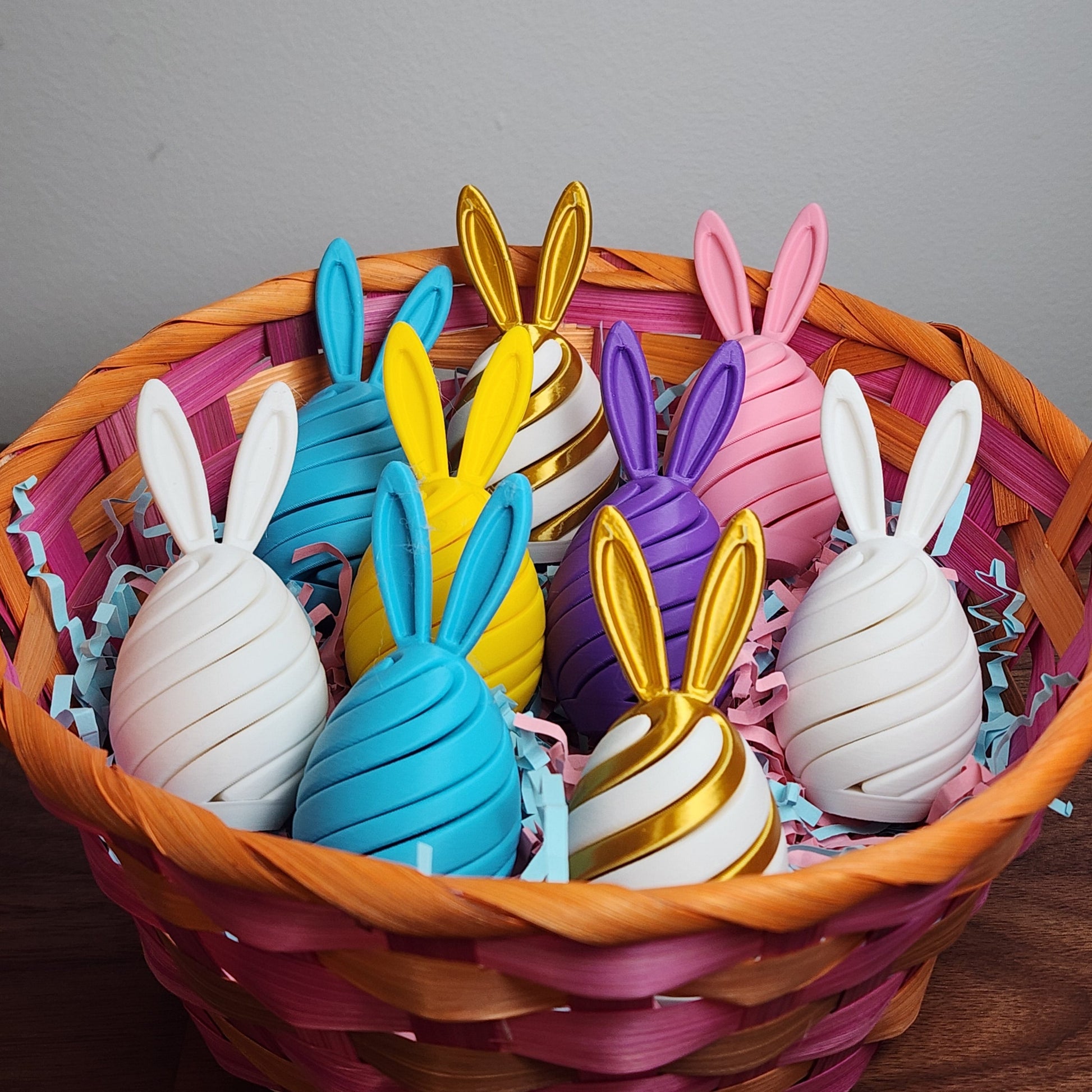 An easter basket of egg shaped spiral fidget toys with bunny ears in various pastel colours