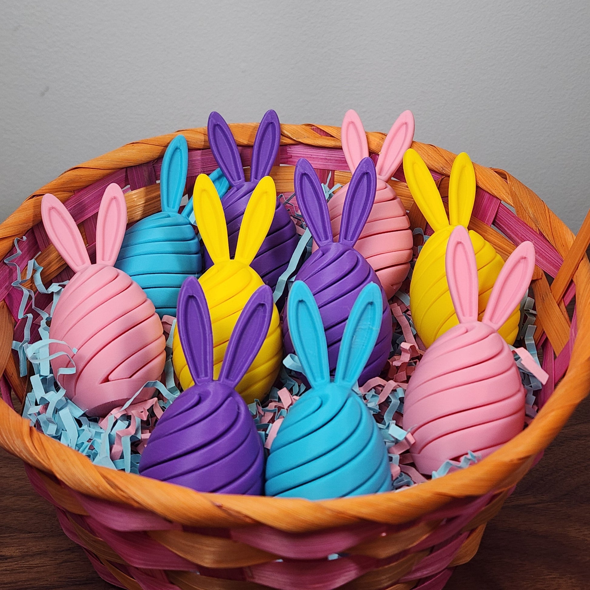 An easter basket of egg shaped spiral fidget toys with bunny ears in various pastel colours