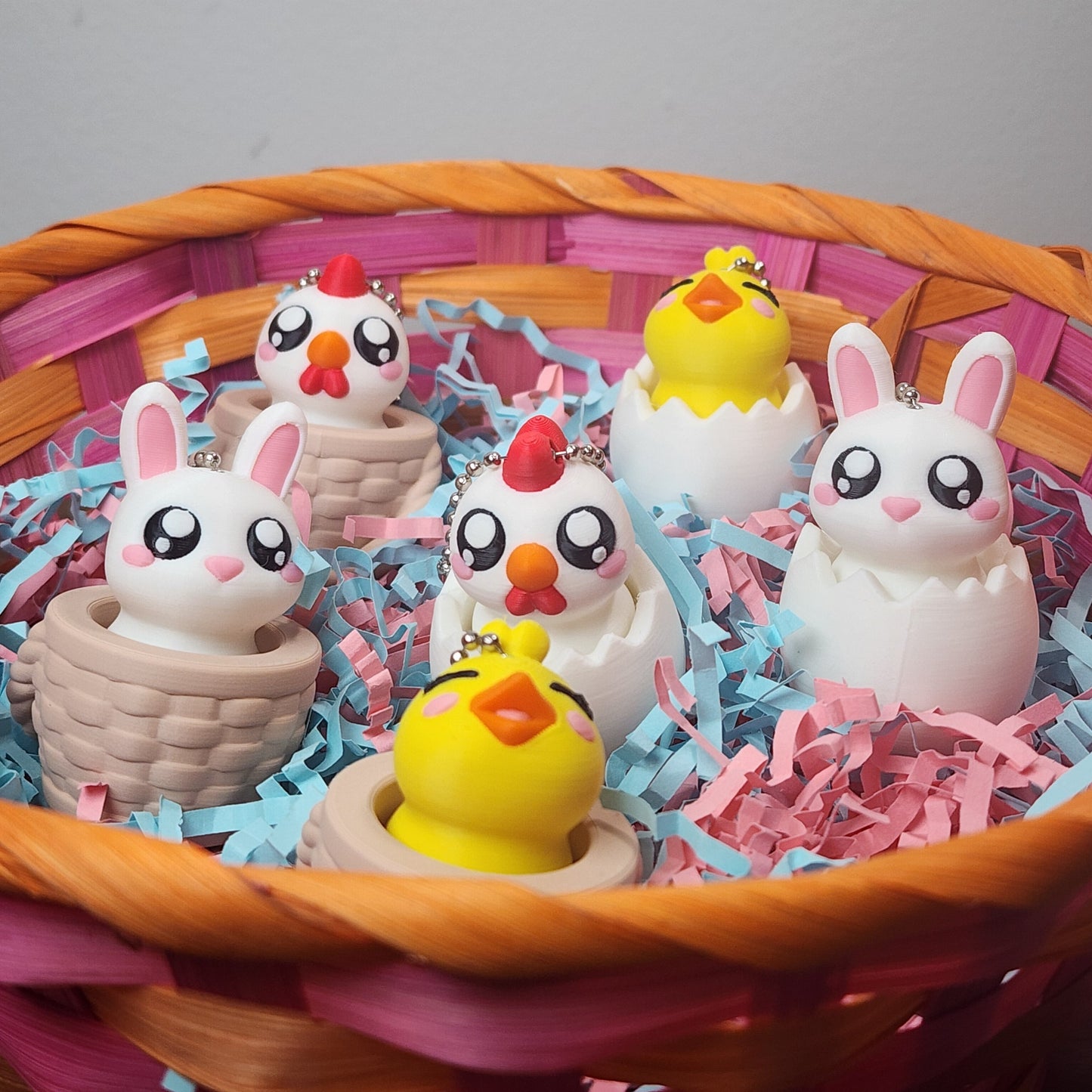 A basket of Easter themed fidget clickers, a bunny in a wicker basket or an egg, a chicken in a wicker basket or an egg, and a chick in a wicker basket or an egg