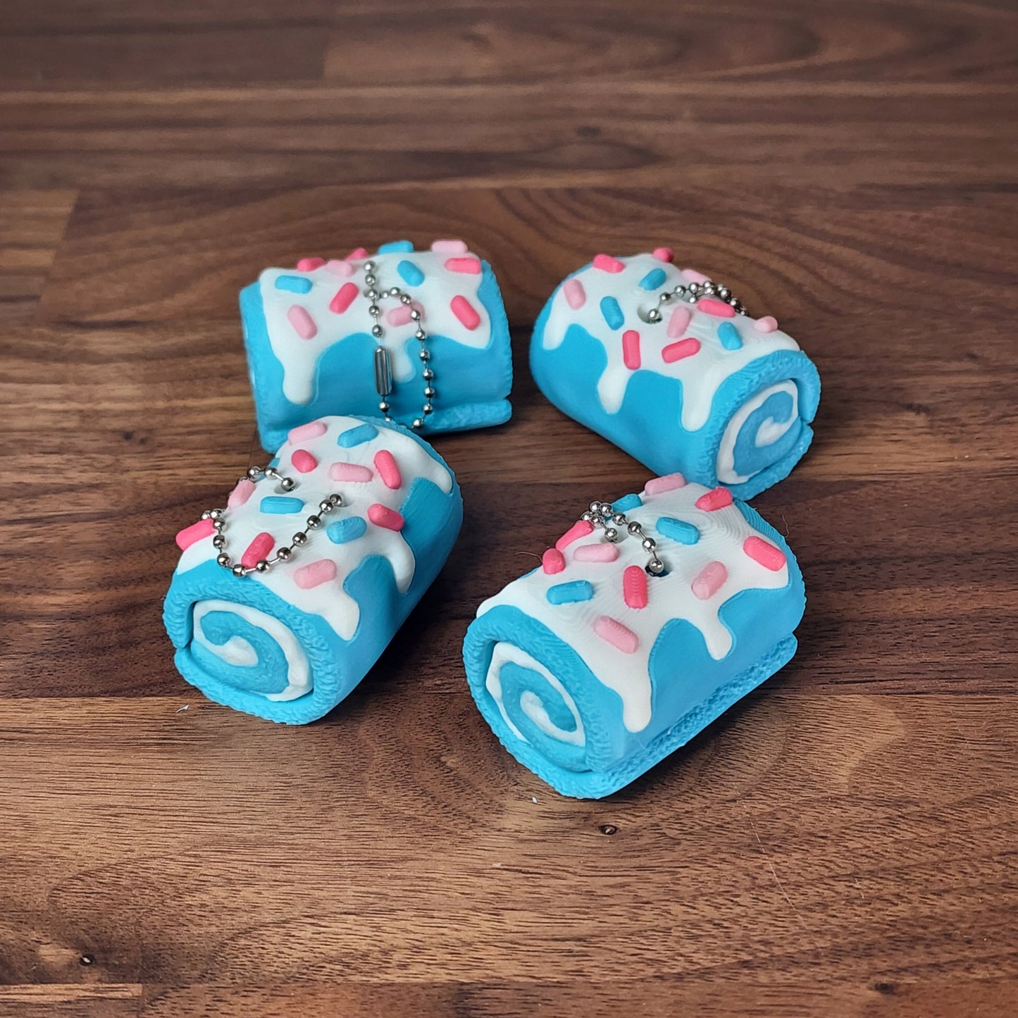 Fidget clickers in the shape of swiss rolls with a birthday cake theme