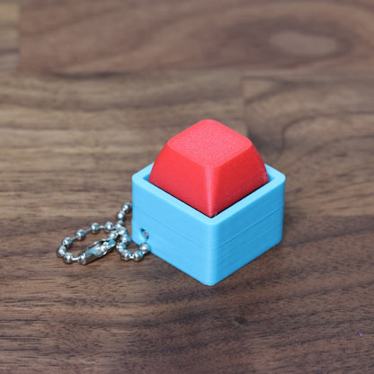 The singularity keyboard fidget clicker with a red keycap and sky blue shell