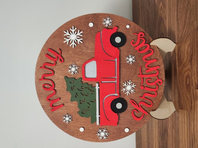 Merry Christmas Sign with a Truck carrying a Tree